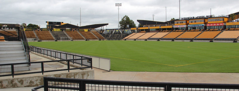 The field and gold seats at Fifth Third Stadium in Kennesaw under a cloudy sky