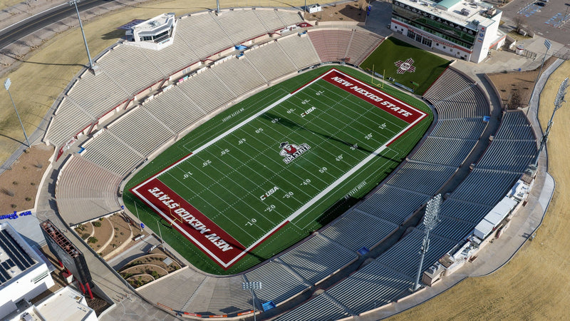 Aerial view of Aggie Memorial Stadium in Las Cruces, with the crimson end zones and the open desert around the bowl