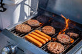 Load image into Gallery viewer, Burgers and hot dogs over open flame on the grill at a tailgate