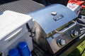 Load image into Gallery viewer, Closed grill next to a white cooler and blue cups in a pickup truck bed