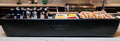 Load image into Gallery viewer, Long black cooler on a kitchen counter with beer bottles on ice, mustard and relish trays and a row of hot dogs