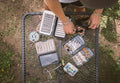 Load image into Gallery viewer, Overhead view of fly-fishing boxes and tools spread across a Tire Table.