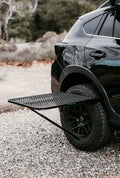 Load image into Gallery viewer, Tire Table mounted on a black SUV's rear tire on gravel.