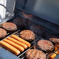 Load image into Gallery viewer, Burgers and hot dogs cooking over flame on the grates of the open grill