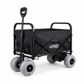 Load image into Gallery viewer, Black folding wagon with gray balloon wheels, push handle raised and battery motor unit under the rear, on a white background