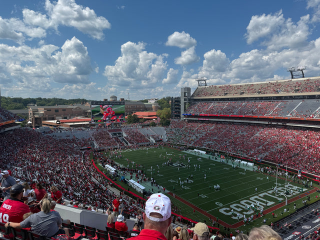 A packed Sanford Stadium in Athens on a Georgia game day, under big clouds