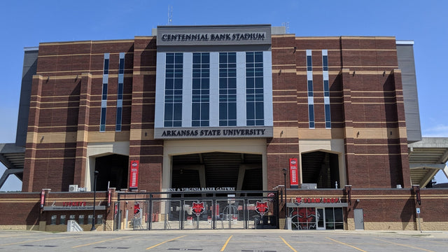 The brick west facade of Centennial Bank Stadium in Jonesboro, with the stadium name above the main gateway