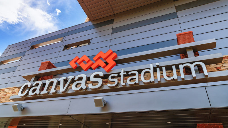 The Canvas Stadium sign on the stadium facade in Fort Collins under a blue sky