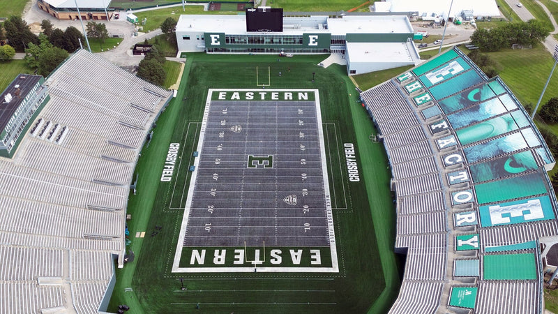 Aerial view of Rynearson Stadium in Ypsilanti, with its gray turf field between the stands