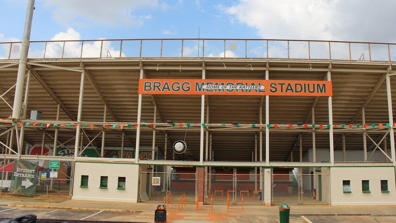 The east face of Bragg Memorial Stadium at FAMU in Tallahassee, with the stadium name on an orange sign above the gates