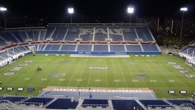 Flagler Credit Union Stadium in Boca Raton at night, seen from the upper deck across the empty field