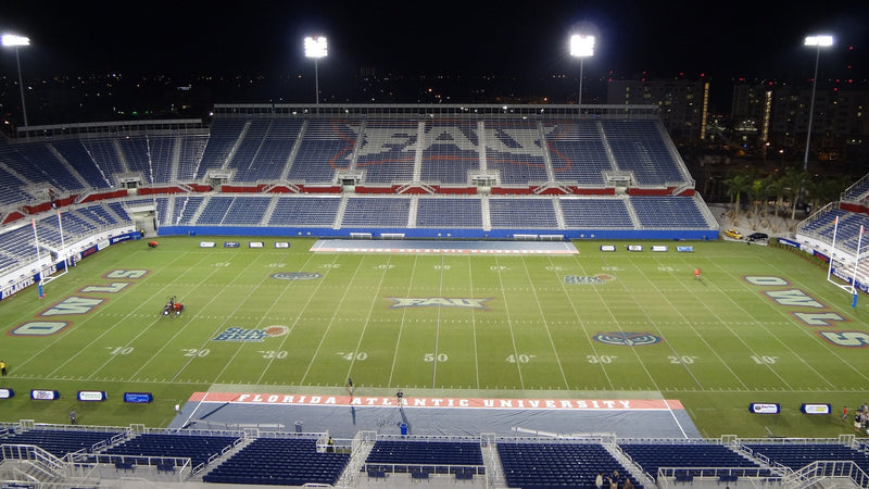 Flagler Credit Union Stadium in Boca Raton at night, seen from the upper deck across the empty field