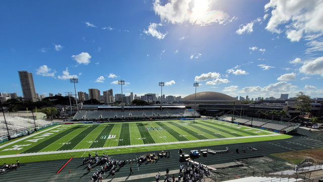 The field at the Clarence T.C. Ching Athletics Complex on the UH Manoa campus, with the Honolulu skyline behind the far stands