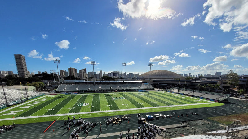 The field at the Clarence T.C. Ching Athletics Complex on the UH Manoa campus, with the Honolulu skyline behind the far stands