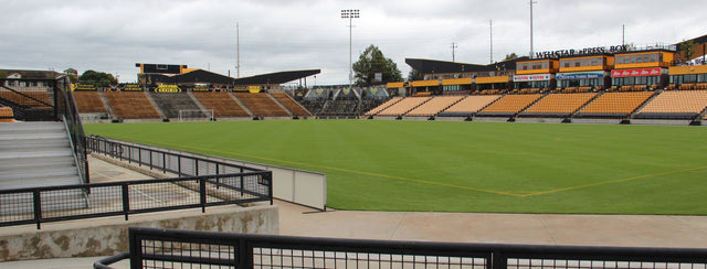 The field and gold seats at Fifth Third Stadium in Kennesaw under a cloudy sky