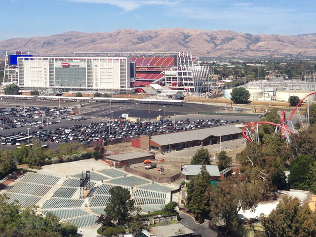 Levi's Stadium in Santa Clara, with a parking lot in front and dry hills behind