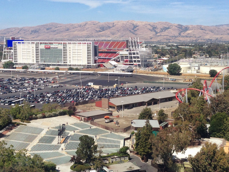 Levi's Stadium in Santa Clara, with a parking lot in front and dry hills behind