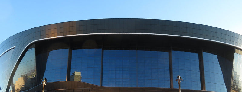 The glass north face of Allegiant Stadium in Las Vegas on a sunny college game day