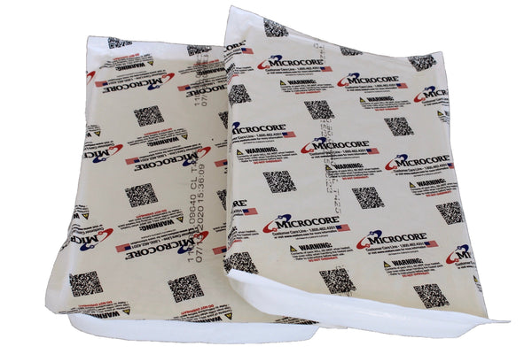 Two flat white heat packs printed with Microcore logos, QR codes and warning labels, on white