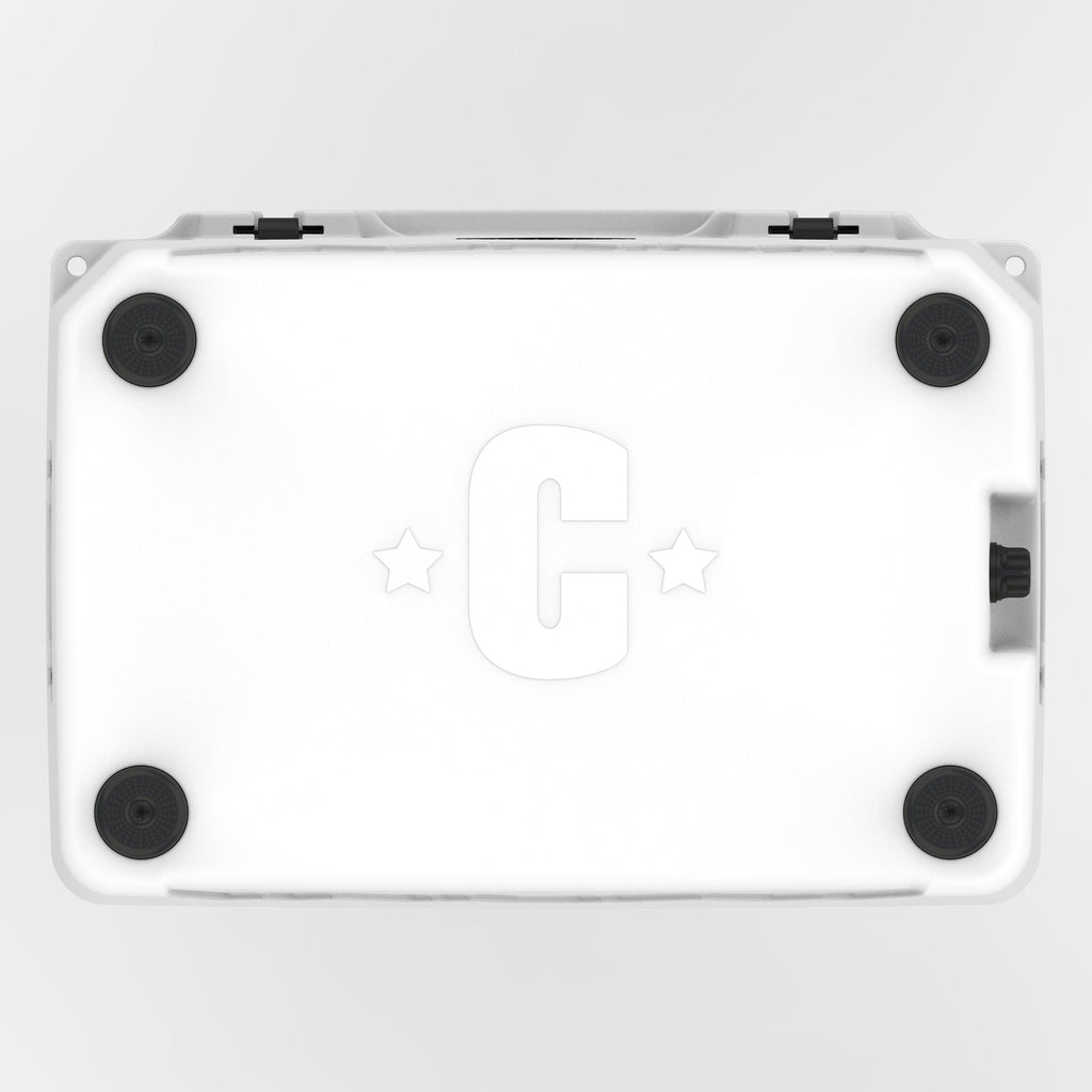 Underside of the white hard cooler with four black rubber feet and a molded C logo