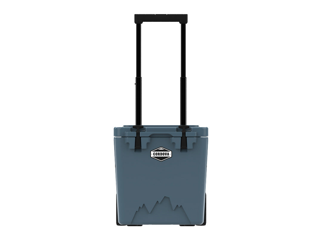 Slate-blue wheeled cooler from the front, handle raised, on white