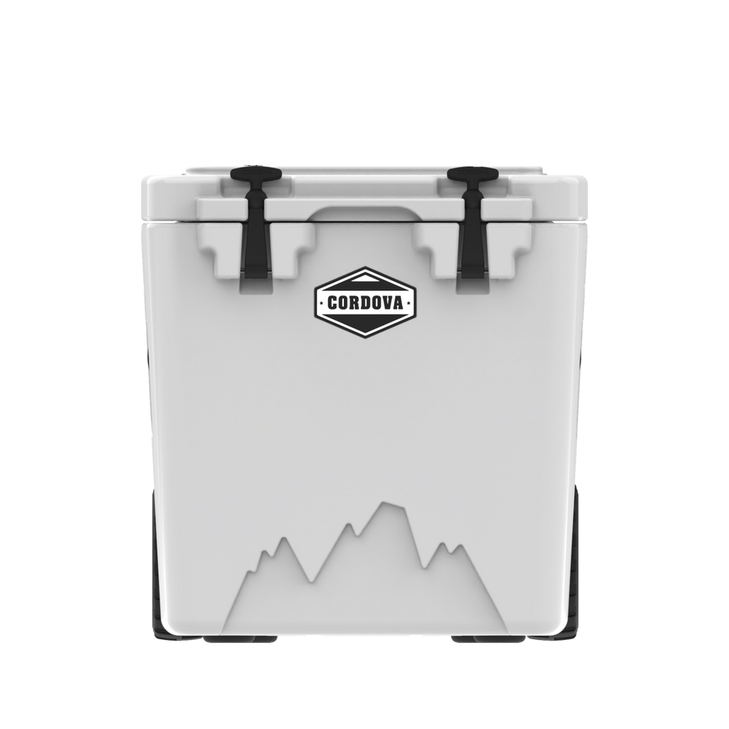 White wheeled hard cooler from the front, two black rubber latches and a mountain graphic, on black