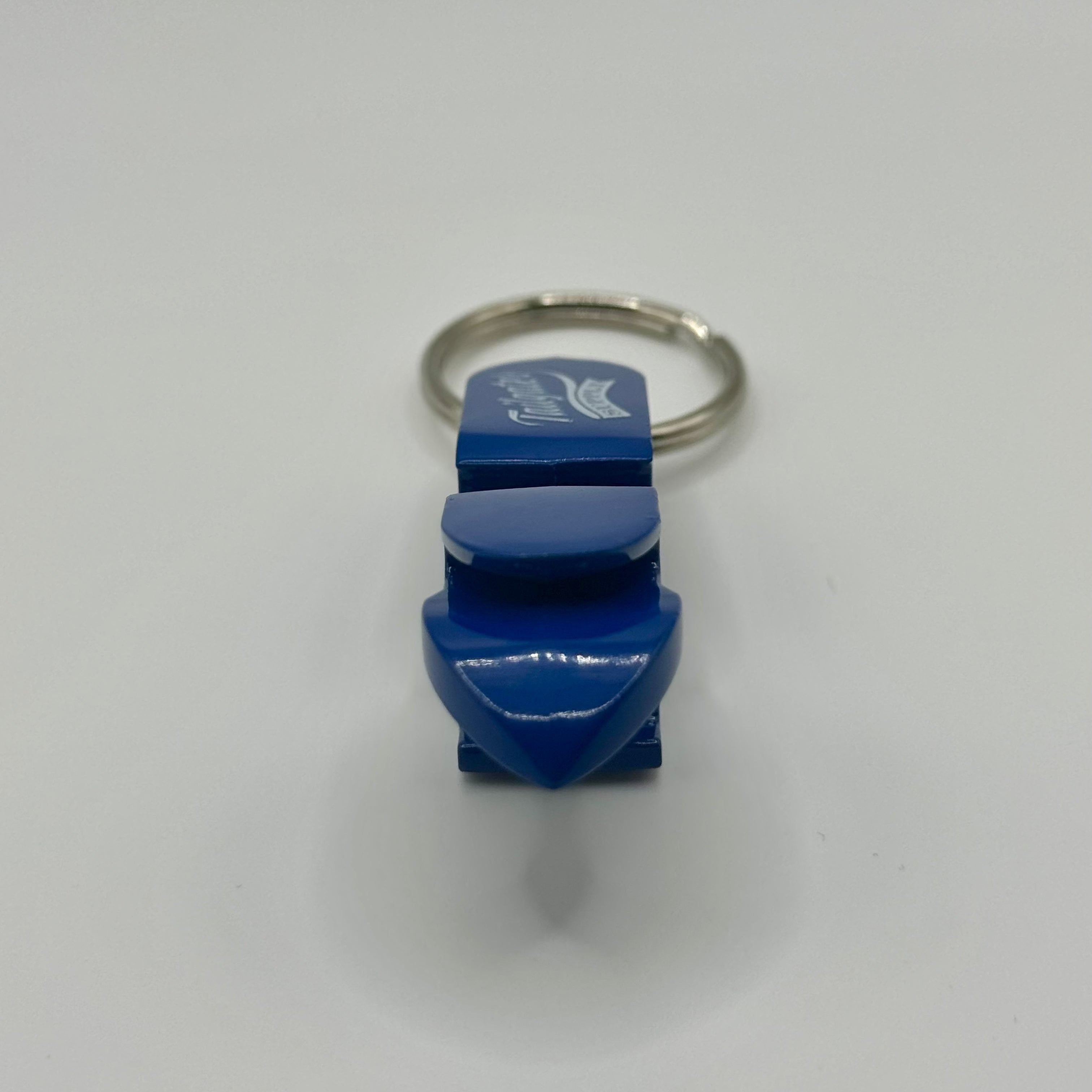 End-on view of the blue opener and shotgun tool, showing the pointed tip used to punch a hole in a can