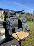Load image into Gallery viewer, Daylodge Workspace field bag hanging from a truck tailgate with its bamboo board folded down as a table
