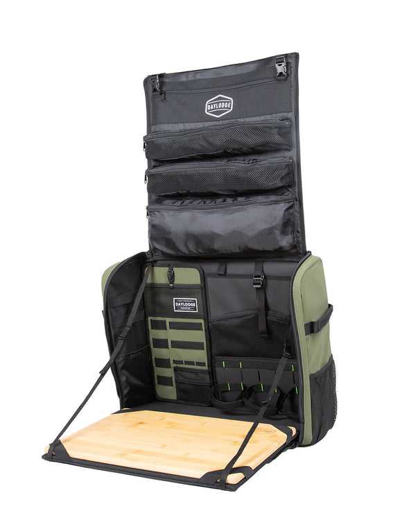 Sage green kitchen bag fully open: zip pockets in the lid, organizer panels, and the bamboo board on two straps