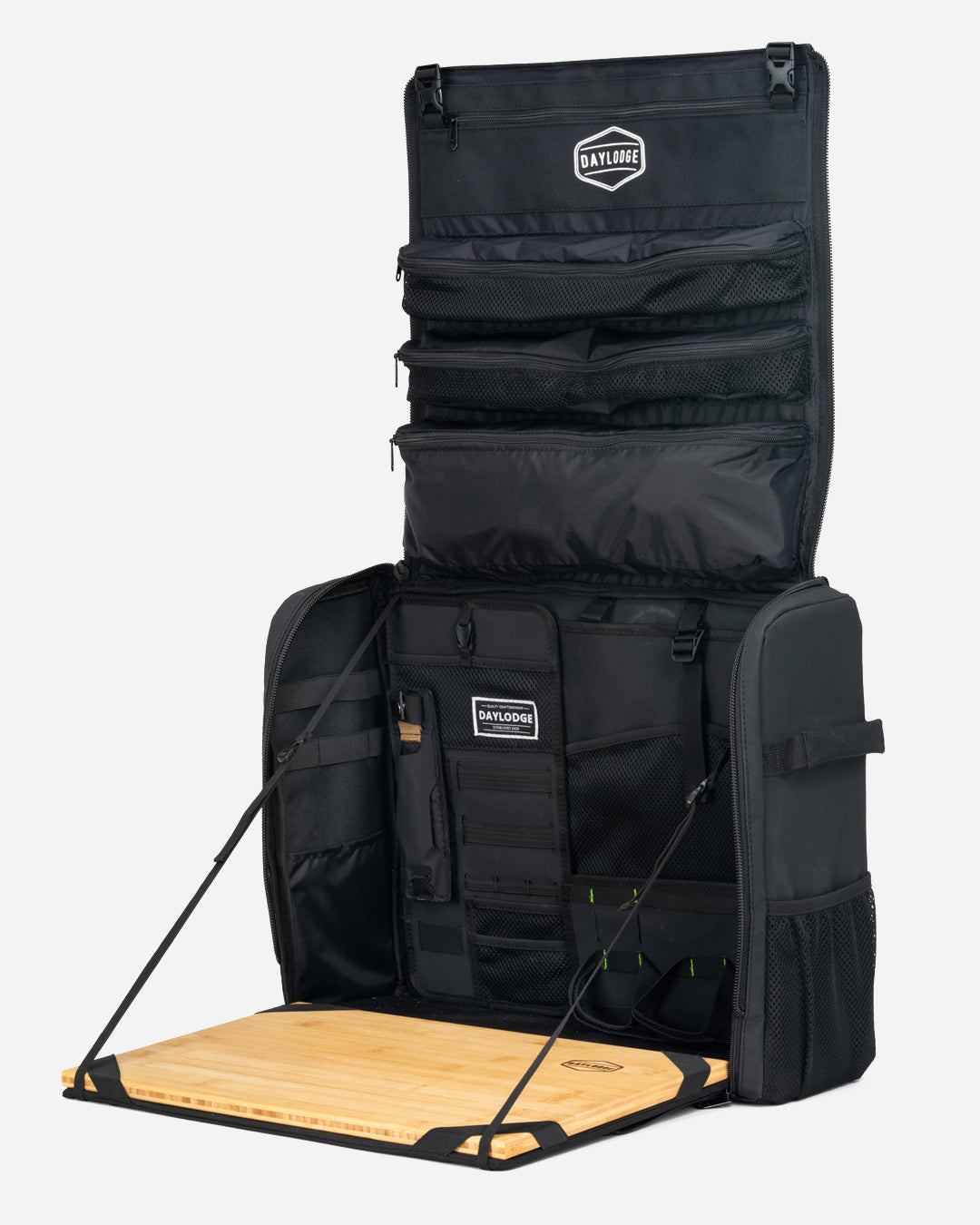 Black kitchen bag fully open, with the lid pockets up and the bamboo board folded out, on light gray