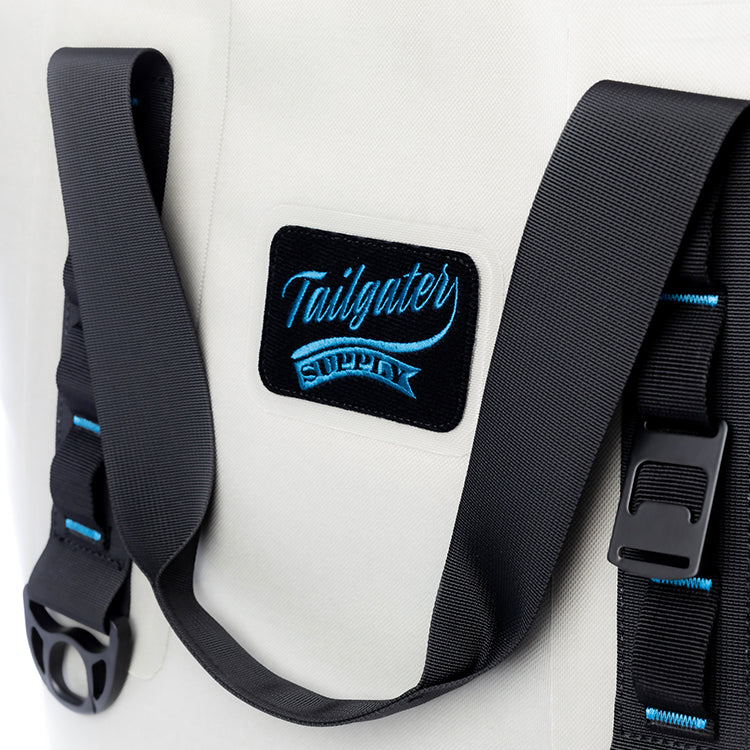 Close-up of the Tailgater Supply patch, buckle and blue-stitched carry strap on the Sidekick