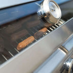 Sausages seen through the window strip in the closed lid, under the lid thermometer
