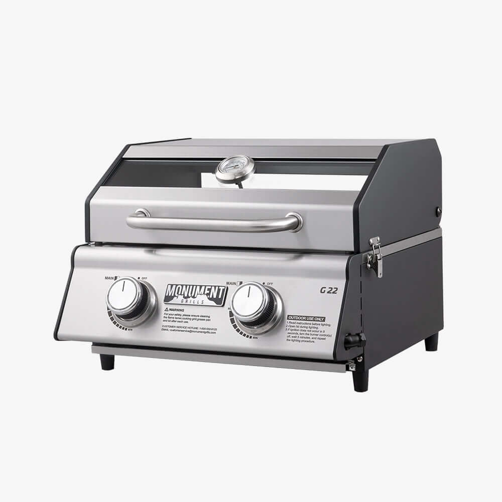 Angled view of the G22 grill with black side panels, the window in the lid, a thermometer and a side latch